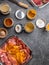 Raw meat in different marinades as soy sauce, pomegranate sauce, spices and herbs in a glass bowls