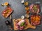 Raw meat in different marinades as soy sauce, pomegranate sauce, spices and herbs in a glass bowls