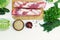 Raw meat, fresh green vegetables, cereals, spices on a white background.