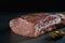 Raw meat on a gray background. A large piece of fresh mouth-watering meat with garlic and pepper. Culinary concept