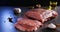 Raw meat. Juicy, appetizing chop with a piece and cut with spices and oil on a gray background