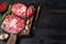 Raw meat osso buco veal shank steak , making italian ossobuco. Black Wooden background. Top view. Copy space