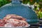 Raw meat in a plate, cut into pieces, seasoned and ready to grill, outdoors, against the backdrop of a ceramic barbecue