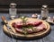 Raw meat with rosemary, garlic, salt and pepper on a wooden board with a fork