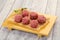 Raw meatball over wooden background