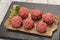 Raw meatball over wooden background