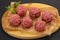 Raw meatball over wooden background