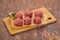 Raw meatball over wooden background