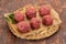 Raw meatball over wooden background