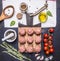 Raw meatballs on a cutting board with vegetables and herbs, oil, rosemary, garlic wooden rustic background top view close up