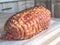 Raw meatloaf on table. Cooked spicy pork meat roulade prepared to roast, marinated with spices and herbs on black slate plate.