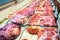 Raw meats displayed in counter of grocery store