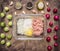 Raw minced meat with flour and onions in a glass bowl with herbs, sprouts and radish on wooden rustic background top view close up