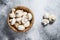 Raw mini mushroom champignon in a bamboo bowl. Gray background. Top view. Space for text