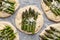 Raw mini pizzas with the addition of green asparagus,  cheese and herbs prepared for baking, close-up.