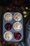 Raw muffin dough with blueberry, raspberry and red currant on rustic wooden table