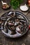 Raw mussels in water on dark wooden table, preparation for cooking