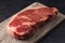 Raw New York Strip Steak on a Dark Slate Surface