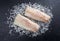 Raw Norwegian skrei cod fish filet on crashed ice on a black board