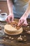 Raw nutty cake decorated with walnut, almond, hazelnut on a dark wooden background. Healthy fresh vegan dessert