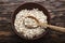 Raw oatmeal flakes in a clay plate on wooden background.