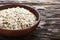 Raw oatmeal flakes in a clay plate on wooden background. healthy carbohydrate breakfast.