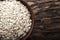 Raw oatmeal flakes in a clay plate on wooden background. healthy carbohydrate breakfast.