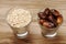 Raw oatmeal in a glass and dry finca in a glass on a wooden table