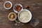 Raw oatmeal in a white bowl, peanut butter, dates fruits, cocoa and a glass of water, ingredients for delicious chocolate porridge