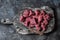 Raw organic beef fillet meat pieces on wooden rustic cutting board on dark background, top view. Food ingredients