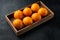 Raw Organic Cara Navel Oranges, in wooden box, on black stone background , with copyspace  and space for text