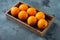 Raw Organic Cara Navel Oranges, in wooden box, on gray stone background , with copyspace  and space for text