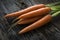 Raw Organic Carrots with Greens on Wood