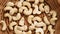 Raw organic cashew nuts in rattan wicker rustic kitchen bowl close up.