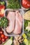 Raw organic chicken breast fillets in plastic packaging tray with various vegetables for tasty cooking, top view. Healthy food