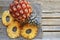 Raw organic dried pineapple slices and fresh ripe ananas fruit on wooden rustic table.