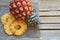 Raw organic dried pineapple slices and fresh ripe ananas fruit on wooden rustic table.