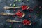 Raw organic fresh cowberry or lingonberry in vintage silver spoons on dark stone table