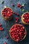 Raw organic fresh cowberry or lingonberry in wooden bowls on dark stone table