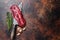 Raw organic machete or skirt steak on a butcher knife . Dark background. Top view. Copy space