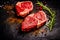 Raw organic marbled beef steaks with spices on a wooden cutting board on a black slate, stone or concrete background