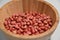 Raw organic redskin peanuts in a bamboo bowl