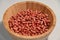 Raw organic redskin peanuts in a bamboo bowl