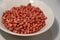 Raw organic redskin peanuts in a white bowl