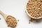 Raw organic soybeans in wooden bowl on white background.