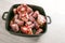 Raw oxtail pieces with bone in a black tray, gelatin-rich meat traditional for a slow-cooking stew or stock base for oxtail soup,