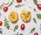 Raw pasta cherry tomatoes arugula heads of garlic white rustic wooden background top view