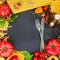 Raw pasta with ingridients on black board