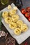 Raw pasta tagliatelle with fresh tomatoes, peppers, asparagus beans, spices and cheese on a wood table