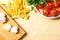 Raw pasta, tomatoes, mushrooms, cutting board, parsley on wooden background, top view. copy space